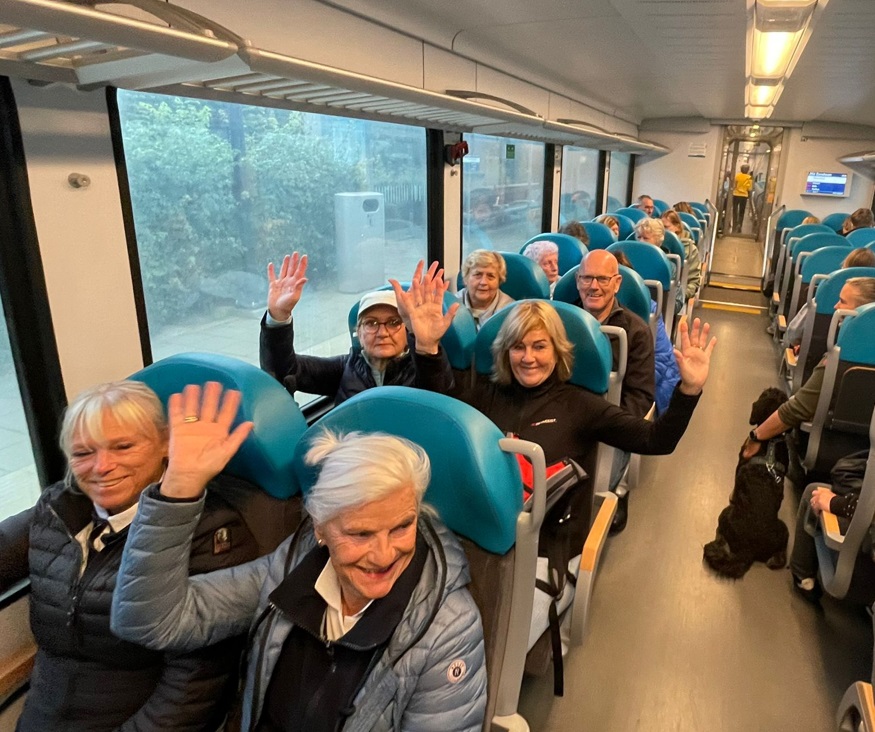 Deelnemers van TodN zitten in Arriva trein en zwaaien