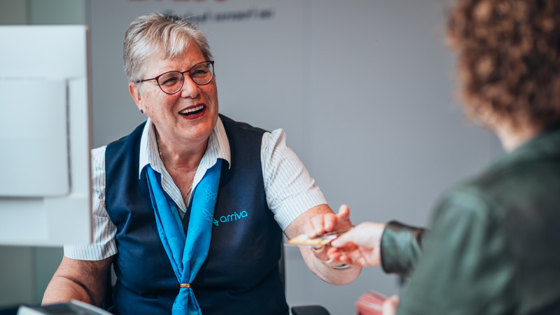 Een lachende service medewerker van Arriva in Tilburg overhandigt een klant haar OV-chipkaart terug. Een lachende service medewerker van Arriva in Tilburg overhandigt een klant haar OV-chipkaart terug.