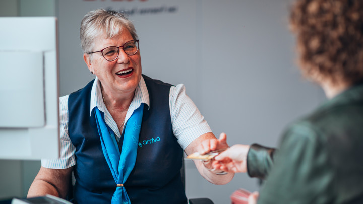 Een lachende service medewerker van Arriva in Tilburg overhandigt een klant haar OV-chipkaart terug. Een lachende service medewerker van Arriva in Tilburg overhandigt een klant haar OV-chipkaart terug.