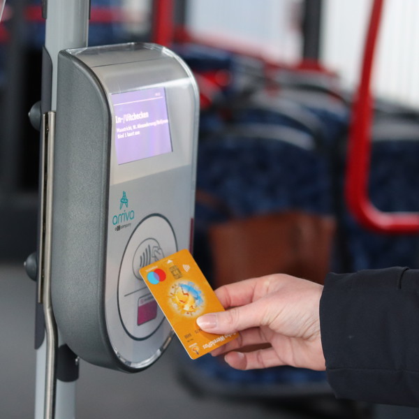 Iemand checkt in een bus van Arriva met de betaalpas in. Iemand checkt in een bus van Arriva met de betaalpas in.