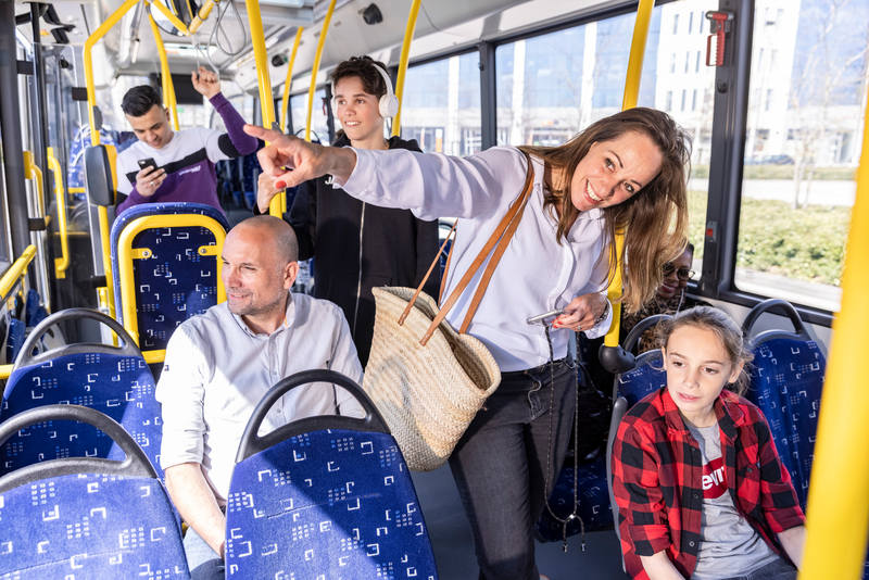 Reizigers in een bus van Arriva, een van hen wijst naar buiten, de rest kijkt.