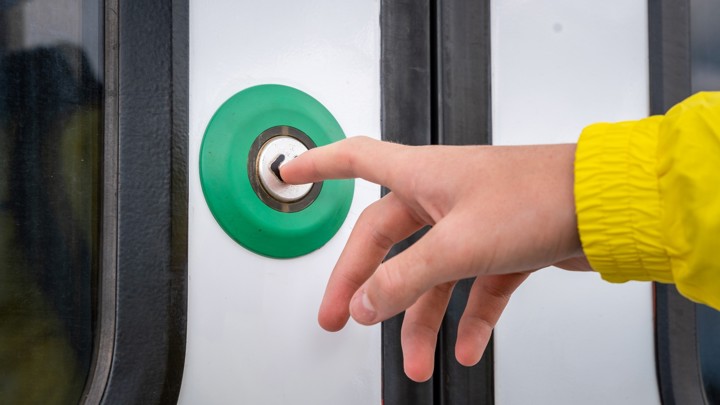 Jongen drukt op de knop om de deuren van een Arriva-trein te openen. Jongen drukt op de knop om de deuren van een Arriva-trein te openen.