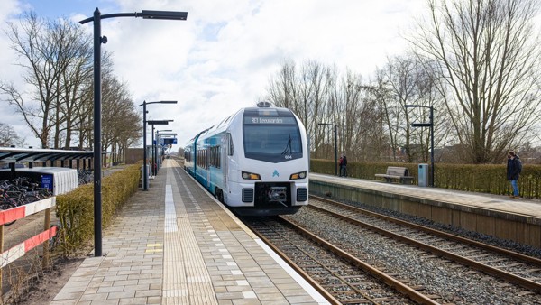 Blauwe trein van Arriva richting Leeuwarden staat stil op een klein station bij een leeg perron op een winterse dag. Blauwe trein van Arriva richting Leeuwarden staat stil op een klein station bij een leeg perron op een winterse dag.