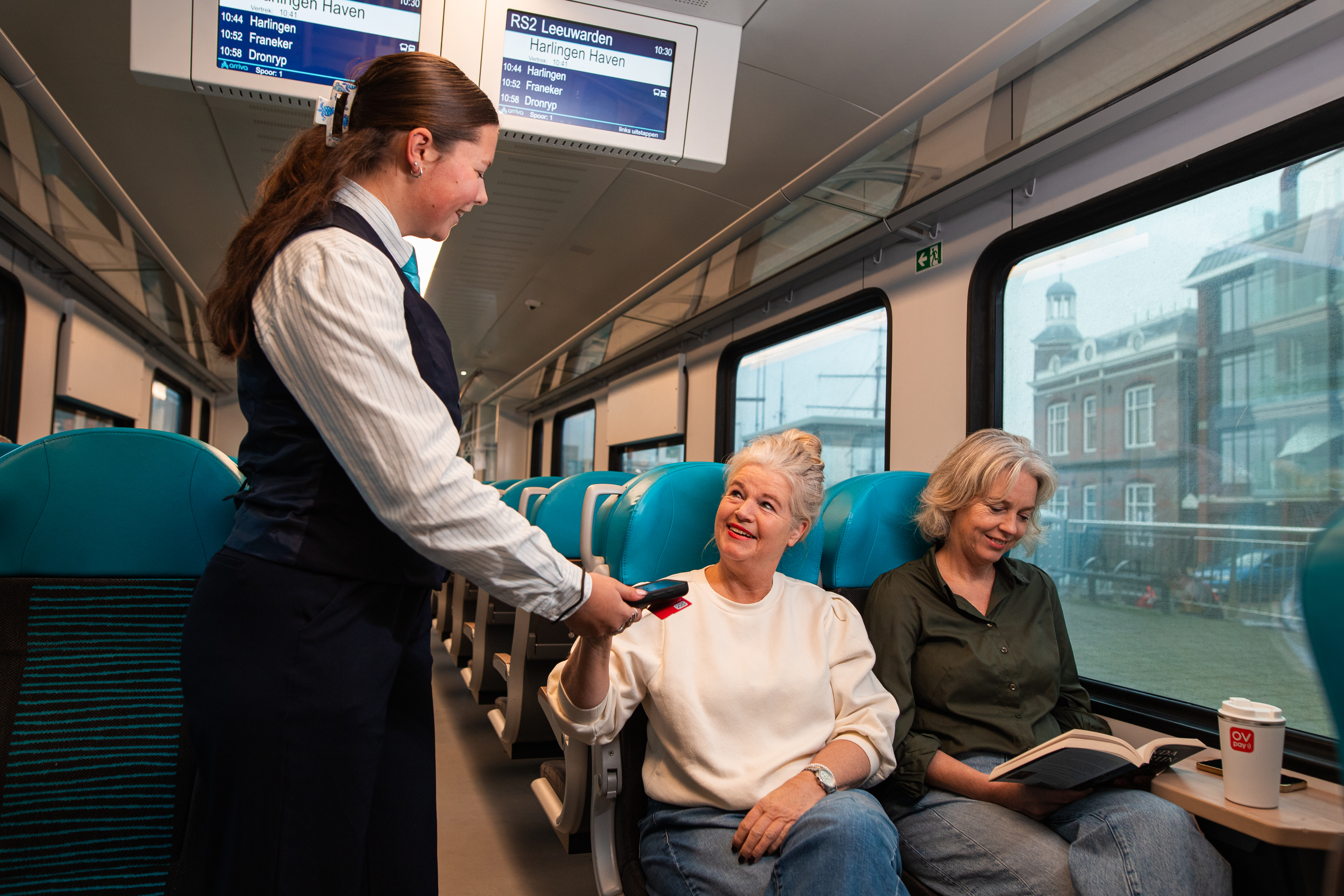 Reizigers worden gecontroleerd door steward in Arriva trein