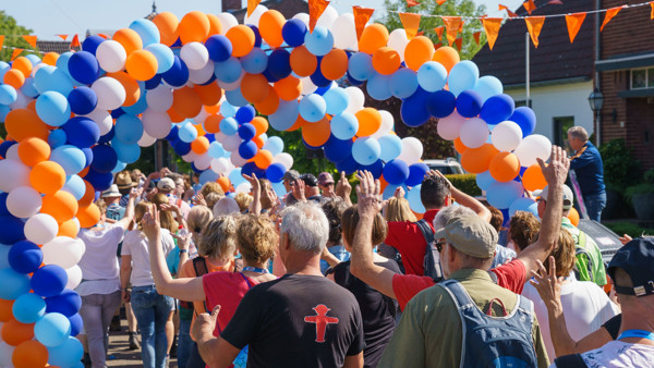 Deelnemers aan de Venloop lopen onder een ballonnenboog door. Deelnemers aan de Venloop lopen onder een ballonnenboog door.