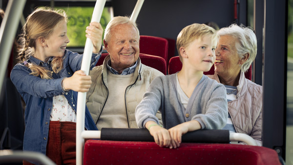 Een opa en oma zitten met hun kleinkinderen in een Arriva-bus. Ze lachen naar elkaar. Een opa en oma zitten met hun kleinkinderen in een Arriva-bus. Ze lachen naar elkaar.