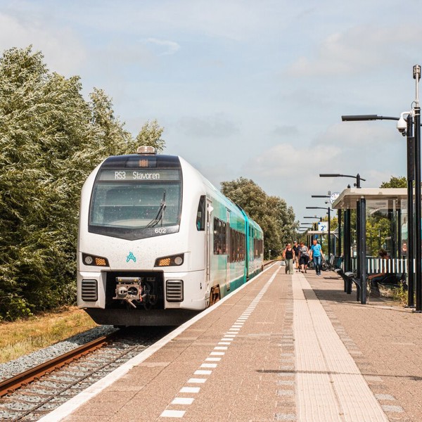 Blauwe Arriva trein staat stil in de zon langs het perron van een klein station. Blauwe Arriva trein staat stil in de zon langs het perron van een klein station.