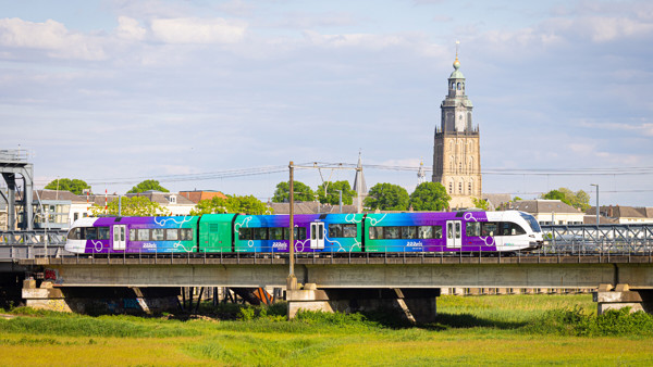 nieuwe trein in de RRReis kleuren op de rails een trein in de RRReiskleuren paars blauw groen op de rails in het Achterhoekse landschap