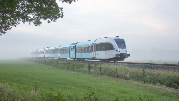 Groene Arriva-trein rijdt door mistige weilanden. Groene Arriva-trein rijdt door mistige weilanden.
