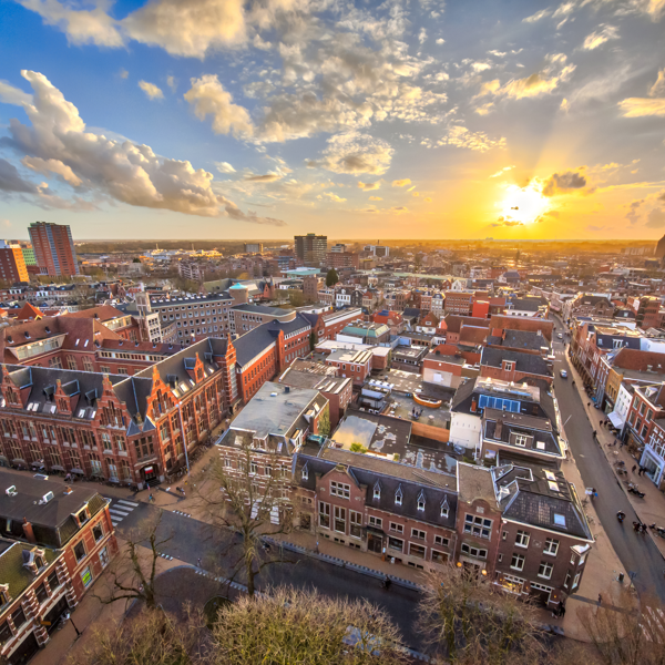Bovenaanzicht van Groningen onder een schilderachtige blauwe lucht met wolken en een stralende zon. Bovenaanzicht van Groningen onder een schilderachtige blauwe lucht met wolken en een stralende zon.