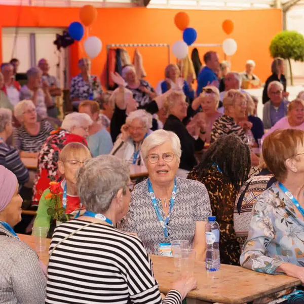 Een groep oudere mensen zit in een tent te lachen en te kletsen tijdens de Venloop. Een groep oudere mensen zit in een tent te lachen en te kletsen tijdens de Venloop.