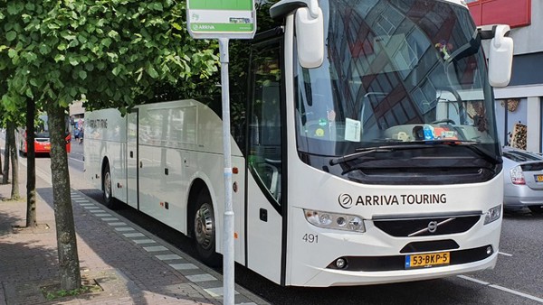 Witte Arriva Touringbus staat bij bushalte geparkeerd. Witte Arriva Touringbus staat bij bushalte geparkeerd.
