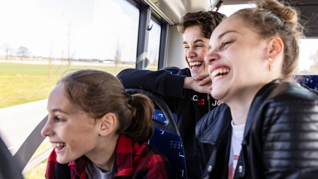 Drie tieners, twee meisjes en een jongen, zitten in een bus van Arriva en moeten om iets lachen dat ze buiten zien. Drie tieners, twee meisjes en een jongen, zitten in een bus van Arriva en moeten om iets lachen dat ze buiten zien.