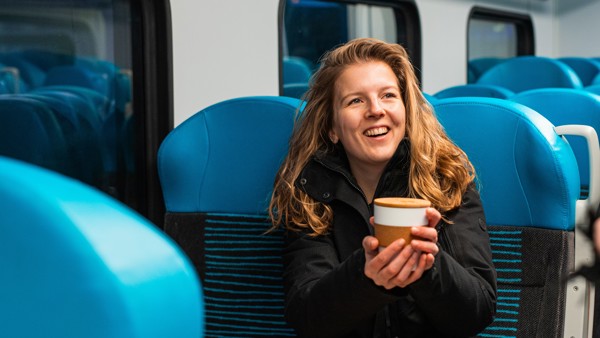 Reiziger drinkt koffietijd in Arriva trein Reiziger drinkt koffietijd in Arriva trein