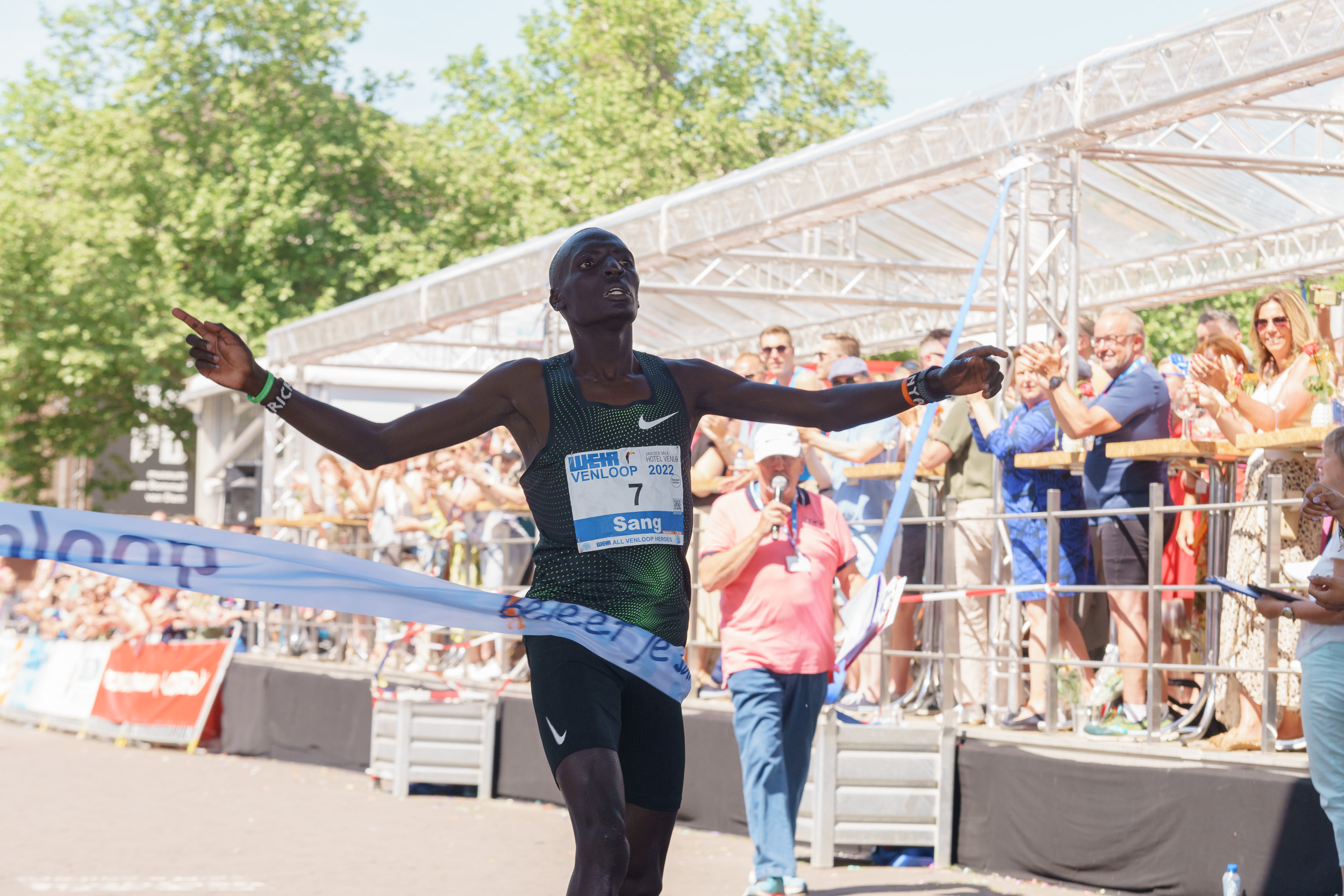 Winnende hardloper finisht als eerst met de armen wijd door het finishlint van de Venloop.