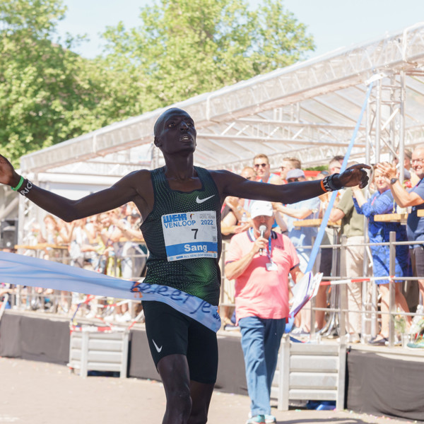 Winnende hardloper finisht als eerst met de armen wijd door het finishlint van de Venloop. Winnende hardloper finisht als eerst met de armen wijd door het finishlint van de Venloop.