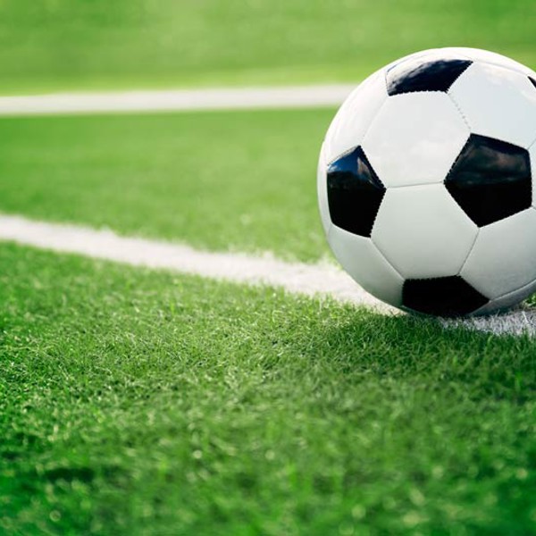 Een groen voetbalveld met een voetbal Een groen voetbalveld met een voetbal