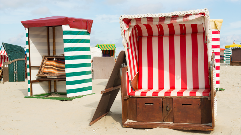 Ouderwetse strandhuisjes met blauwwitte en groenwitte doeken staan op het strand van Borkum. Ouderwetse strandhuisjes met blauwwitte en groenwitte doeken staan op het strand van Borkum.