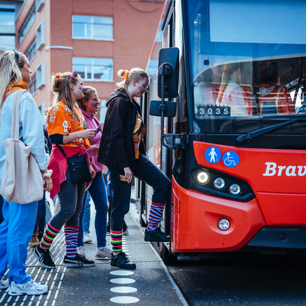 Vrolijk uitgedoste festivalgangers stappen in Bravo-bus tijdens carnaval. Vrolijk uitgedoste festivalgangers stappen in Bravo-bus tijdens carnaval.