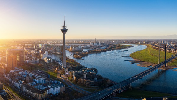 Dusseldorf vanaf boven bekeken met uitzicht op de stad, een grote kronkelende rivier en een hoge radiotoren. Dusseldorf vanaf boven bekeken met uitzicht op de stad, een grote kronkelende rivier en een hoge radiotoren.